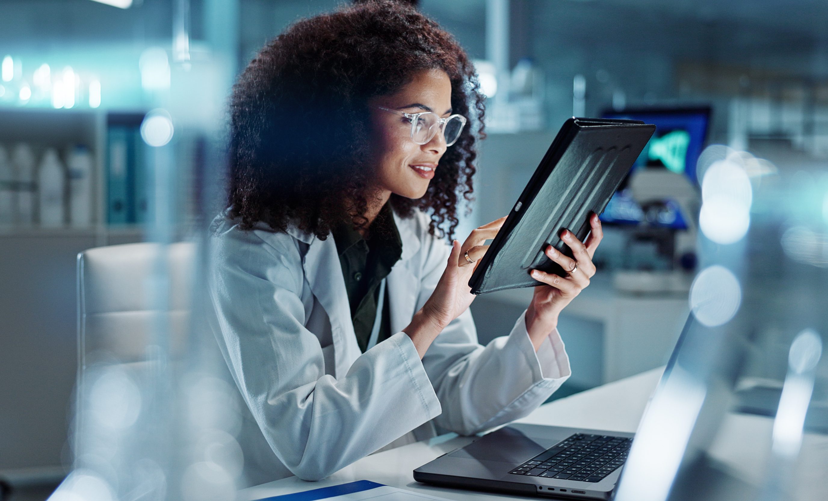 A scientist with a tablet at a laboratory workstation.